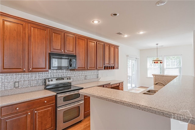 143 Regency Cir, Pooler, GA 31322 - kitchen with double oven range, black microwave, decorative backsplash, brown cabinets, and recessed lighting