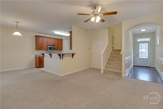 650 Summer Hill Way, Richmond Hill, GA 31324 - unfurnished living room featuring light colored carpet, arched walkways, stairs, and a ceiling fan