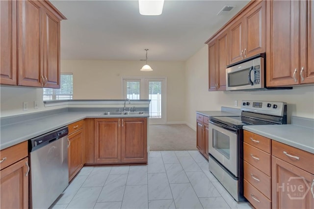 650 Summer Hill Way, Richmond Hill, GA 31324 - kitchen with stainless steel appliances, a peninsula, brown cabinetry, and healthy amount of natural light
