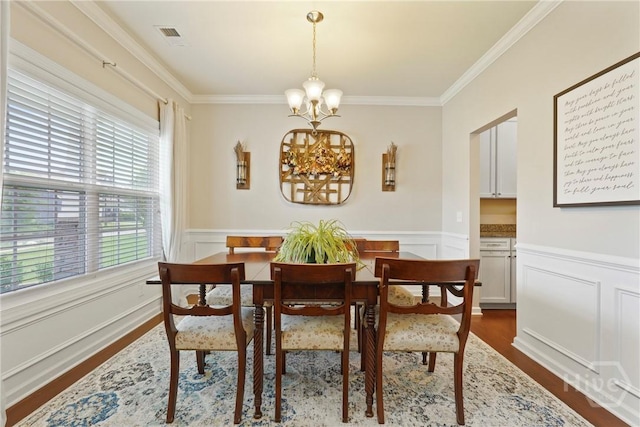 121 Belle Gate Dr, Pooler, GA 31322 - dining space with dark wood-style floors, a chandelier, crown molding, wainscoting, and a decorative wall