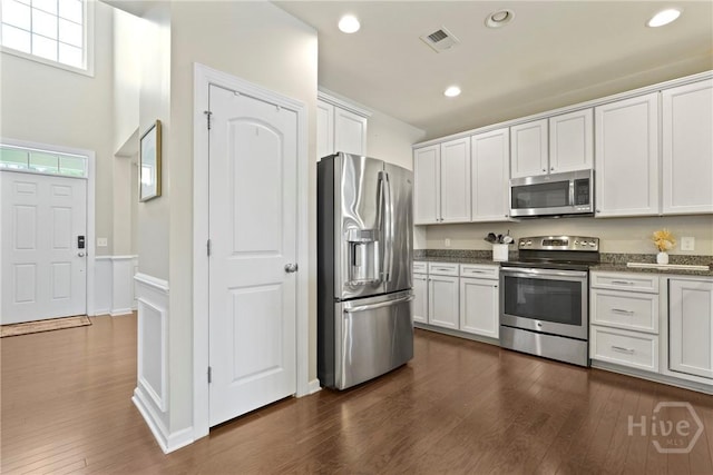 121 Belle Gate Dr, Pooler, GA 31322 - kitchen with stainless steel appliances, white cabinetry, dark wood-style floors, a wainscoted wall, and recessed lighting