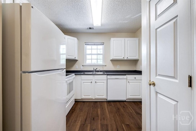 310 Tibet Ave Unit 52, Savannah, GA 31406 - kitchen featuring white appliances, dark countertops, a textured ceiling, white cabinets, and dark wood-type flooring
