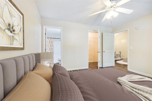 310 Tibet Ave Unit 52, Savannah, GA 31406 - bedroom with connected bathroom, a walk in closet, a textured ceiling, wood finished floors, and a ceiling fan