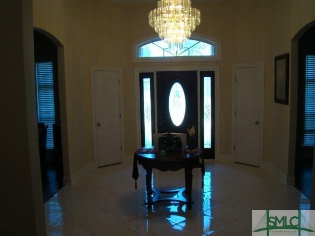 tiled entrance foyer featuring a notable chandelier