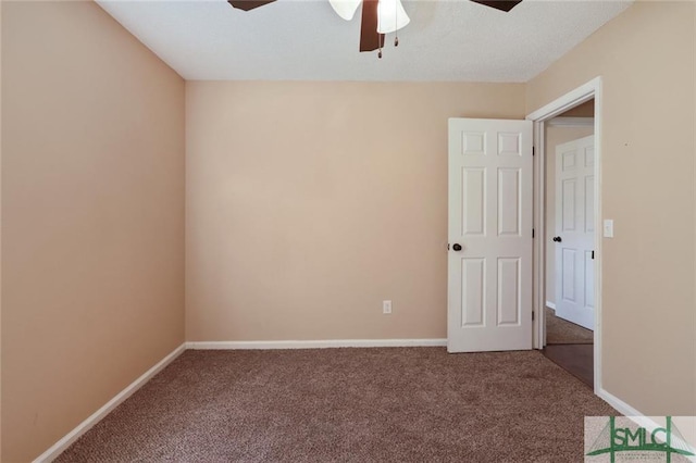 unfurnished room featuring ceiling fan and dark carpet