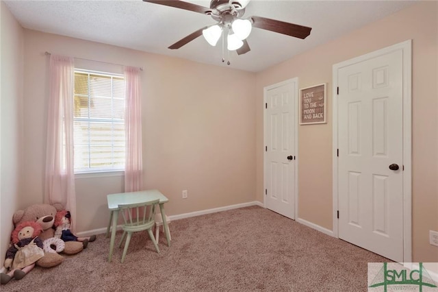 playroom featuring ceiling fan, light carpet, and plenty of natural light