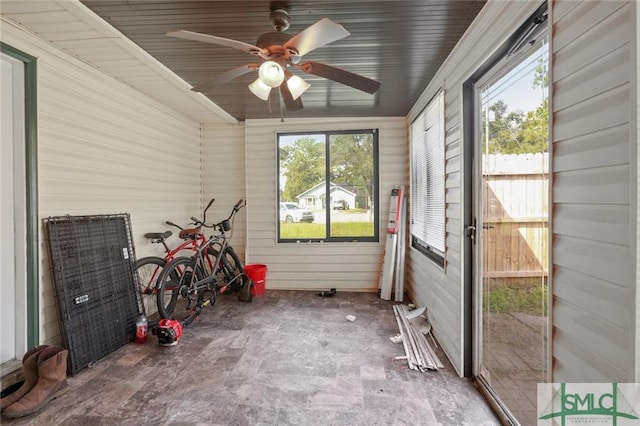 unfurnished sunroom featuring ceiling fan