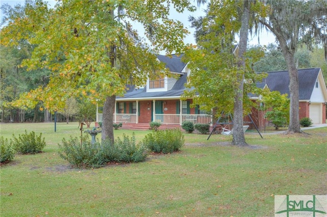 obstructed view of property featuring a front yard, covered porch, and a garage