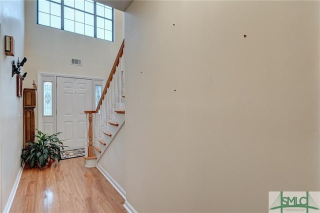 foyer with light hardwood / wood-style flooring and a high ceiling