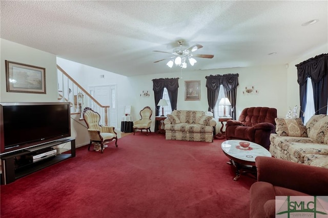 carpeted living room featuring ceiling fan and a textured ceiling