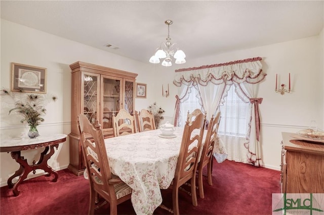 carpeted dining room with a chandelier