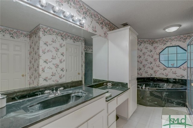 bathroom featuring a tub, tile flooring, vanity, and a textured ceiling