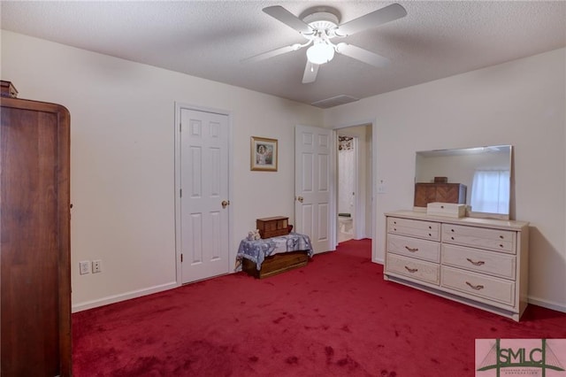 unfurnished bedroom with ceiling fan, a textured ceiling, and dark carpet