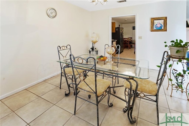 tiled dining room featuring a notable chandelier