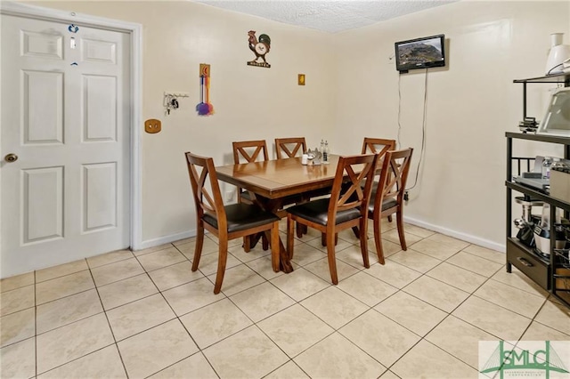 dining room featuring light tile floors and a textured ceiling