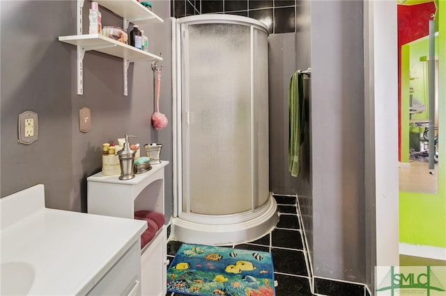 bathroom with an enclosed shower, vanity, and tile flooring