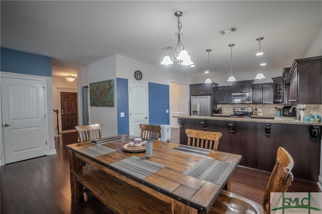 dining space with a notable chandelier, dark hardwood / wood-style floors, and sink