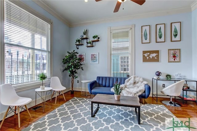 living area featuring ceiling fan, ornamental molding, and dark hardwood / wood-style floors