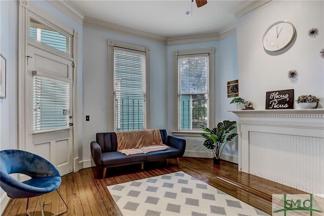 sitting room featuring crown molding, dark wood-type flooring, and a wealth of natural light