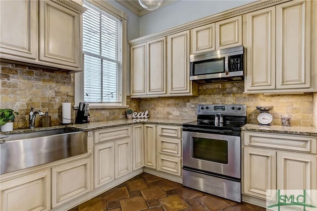 kitchen with plenty of natural light, stainless steel appliances, and cream cabinets