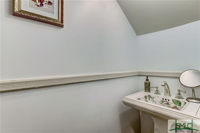 bathroom featuring lofted ceiling and sink