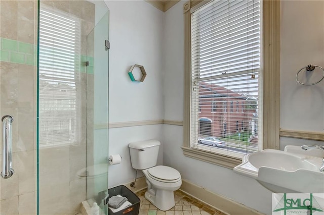 bathroom featuring sink, plenty of natural light, tile flooring, and toilet