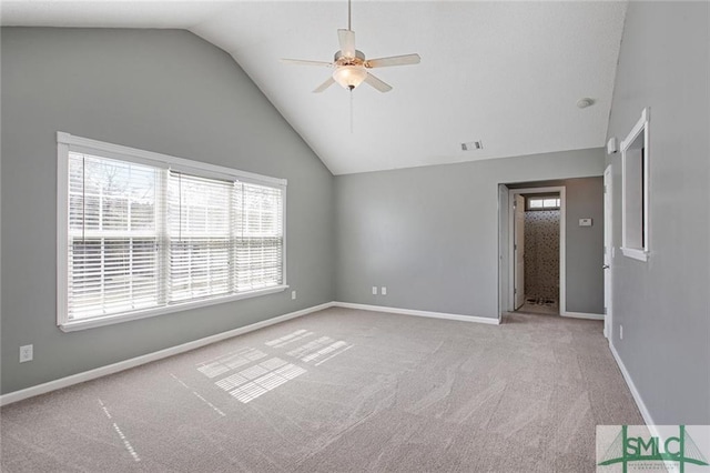 carpeted spare room with plenty of natural light, ceiling fan, and lofted ceiling