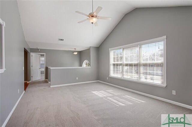 unfurnished room with light carpet, ceiling fan, and vaulted ceiling