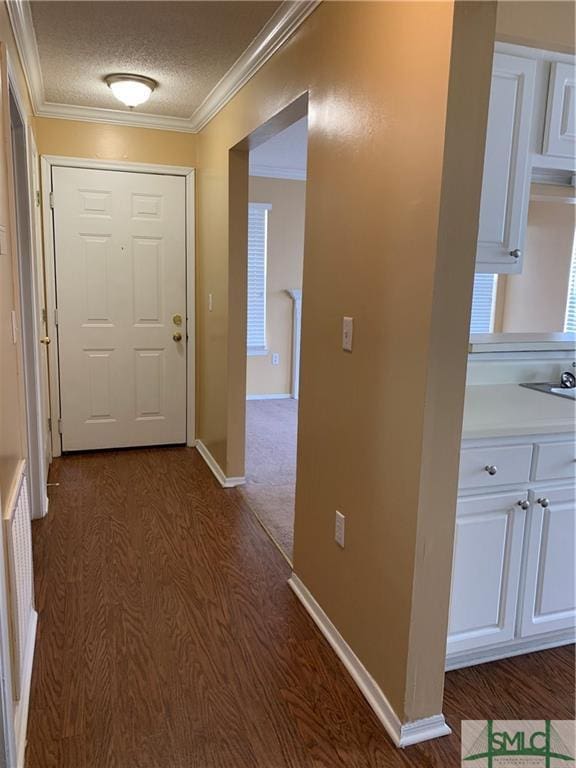 hall featuring ornamental molding, dark hardwood / wood-style floors, and a textured ceiling