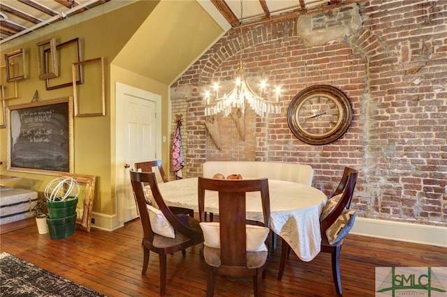 dining space featuring brick wall, vaulted ceiling, and dark wood-type flooring