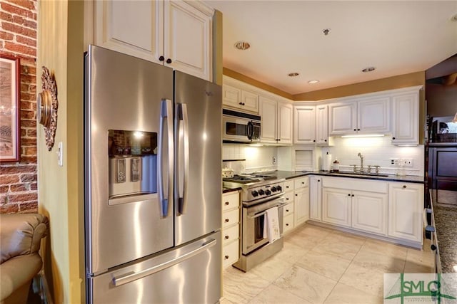 kitchen with backsplash, white cabinetry, appliances with stainless steel finishes, and sink