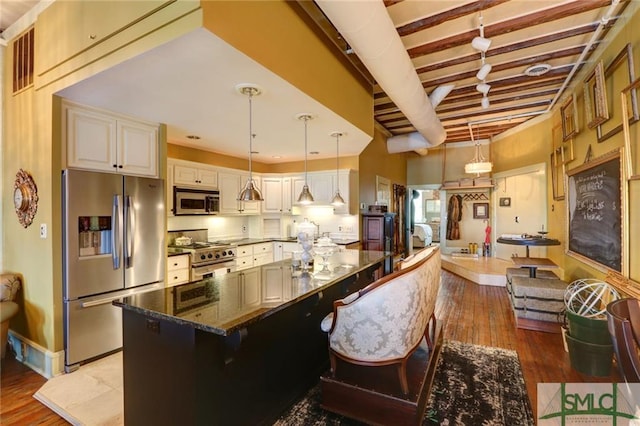 kitchen featuring decorative light fixtures, dark stone counters, appliances with stainless steel finishes, light hardwood / wood-style flooring, and beam ceiling