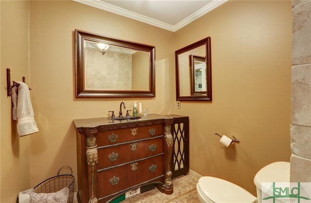 bathroom featuring toilet, ornamental molding, and vanity