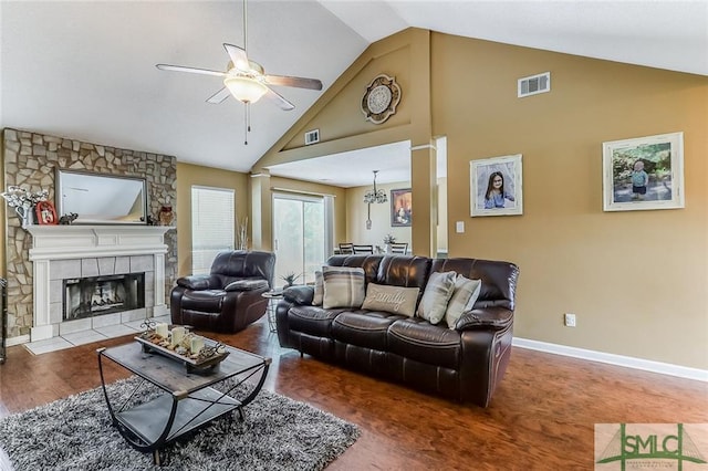 living room featuring high vaulted ceiling, dark hardwood / wood-style floors, ceiling fan, and a fireplace