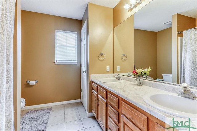 bathroom with tile floors, toilet, and double vanity