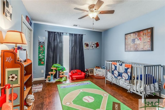 rec room featuring ceiling fan, a textured ceiling, and dark hardwood / wood-style floors