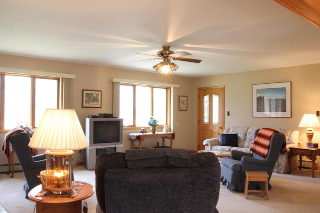 carpeted living room with ceiling fan and a baseboard heating unit