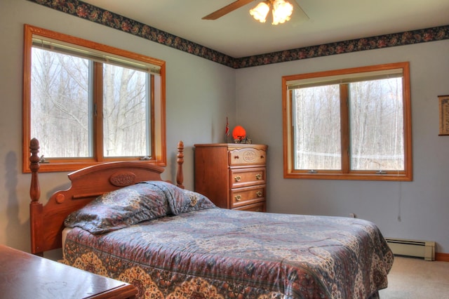 carpeted bedroom with a baseboard radiator and ceiling fan