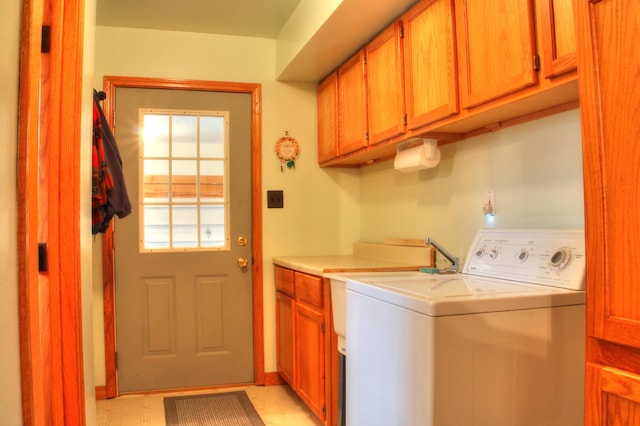 clothes washing area with cabinets and light tile flooring