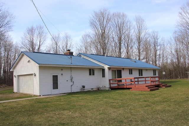 back of house featuring a wooden deck, a garage, and a yard