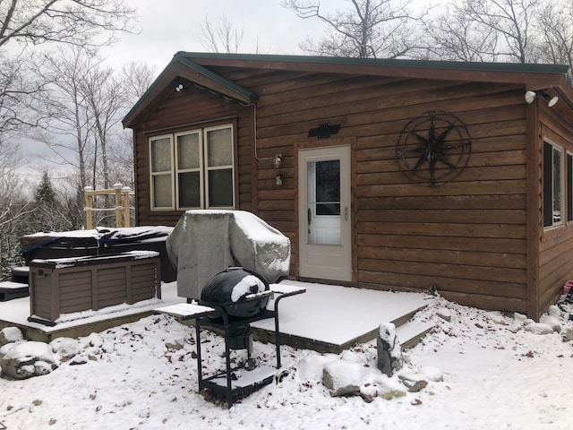 snow covered property featuring a hot tub