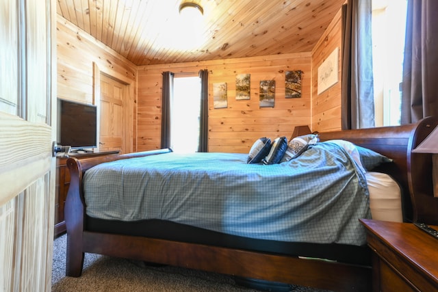 bedroom featuring wooden ceiling, multiple windows, wood walls, and dark carpet