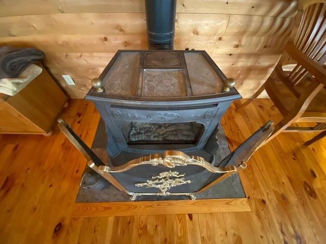 room details featuring a wood stove and wood-type flooring