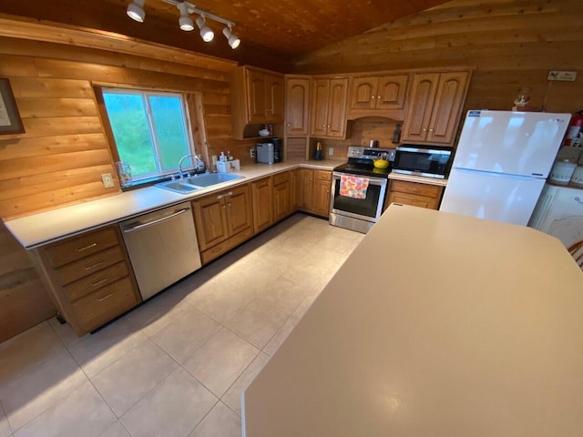 kitchen featuring sink, light tile floors, stainless steel appliances, track lighting, and lofted ceiling