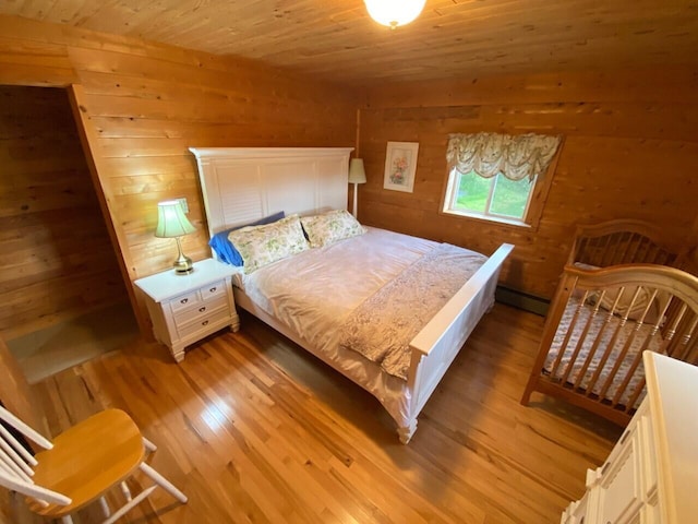 bedroom featuring wooden walls, light hardwood / wood-style floors, and wooden ceiling