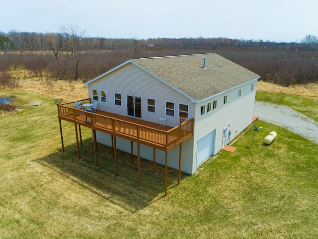 rear view of property featuring a lawn and a deck