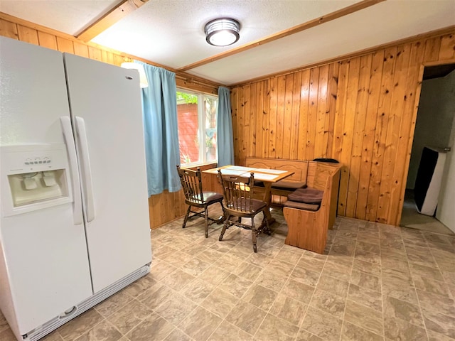 tiled dining area featuring wood walls