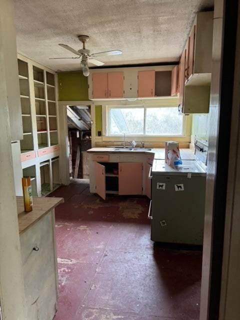 kitchen featuring ceiling fan, sink, and a textured ceiling