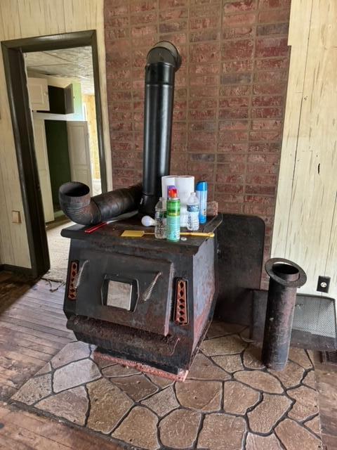 room details featuring wood-type flooring and a wood stove