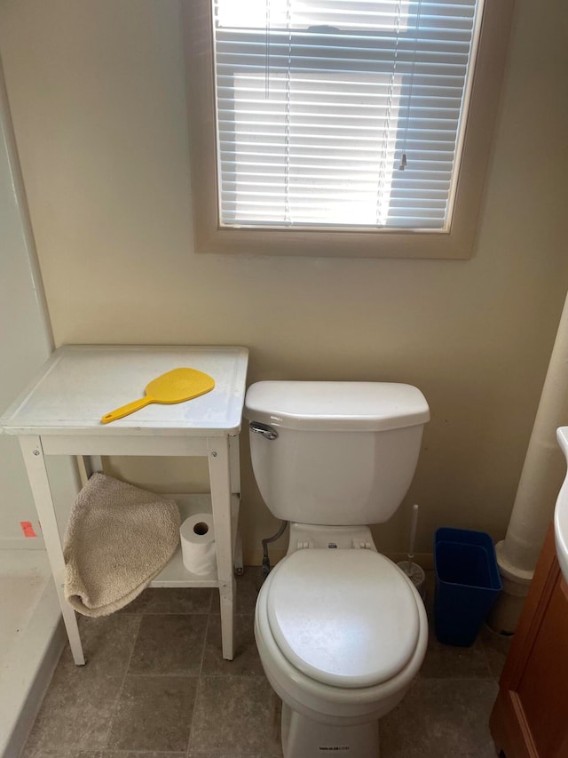 bathroom with toilet and tile flooring